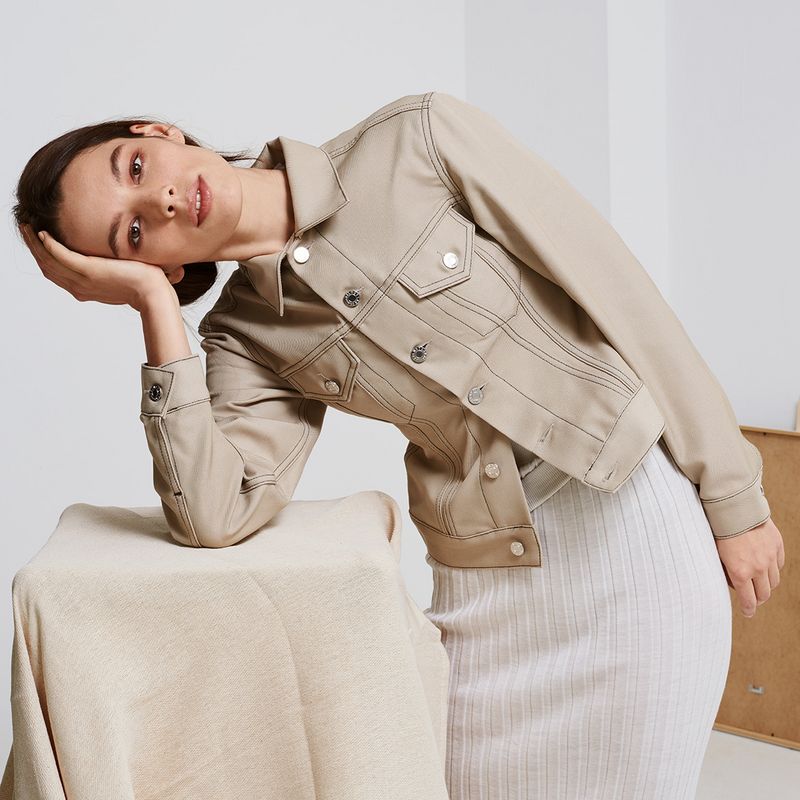 Model wearing trench coat, white shirt and blue jeans by Helmut Lang