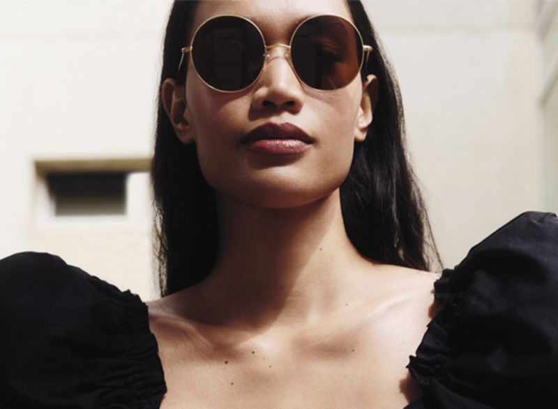Model wearing round sunglasses by Jimmy Choo