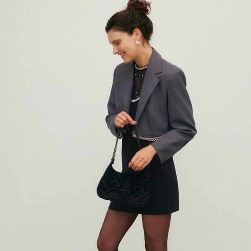 Model wearing black blazer and lace dress by Sandro