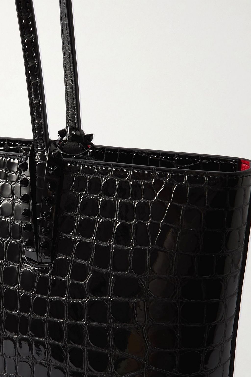 CHRISTIAN LOUBOUTIN حقيبة توت "كاباتا" من الجلد اللامع بنقشة جلد التمساح مزينة بدبابيس معدنية مدببة