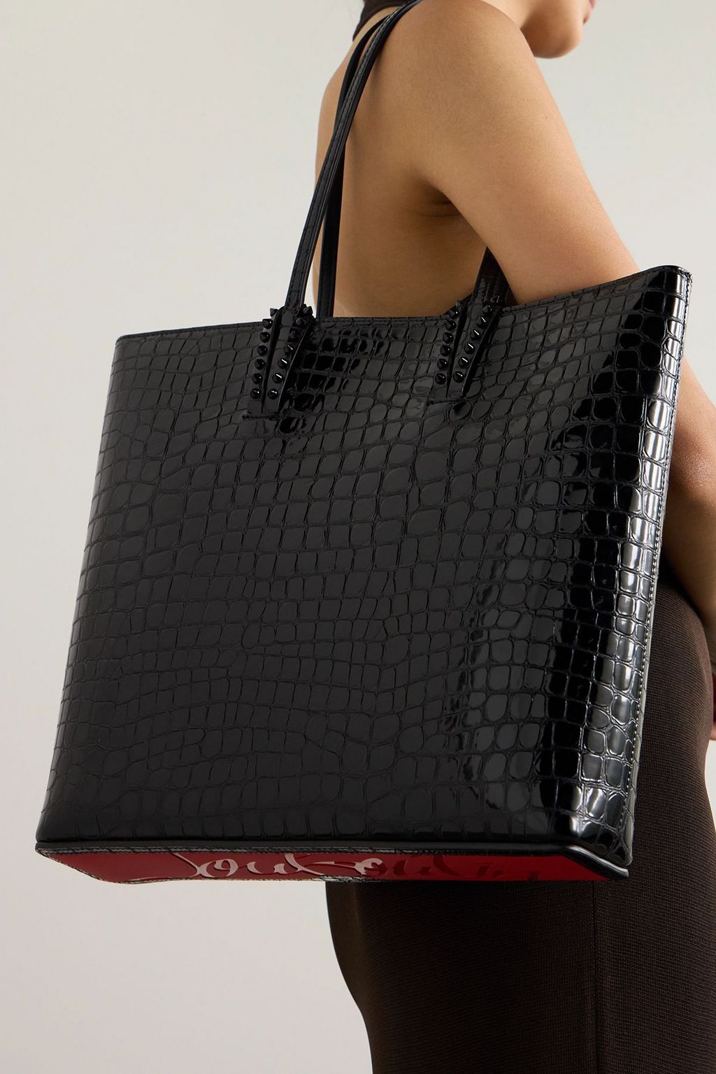 CHRISTIAN LOUBOUTIN حقيبة توت "كاباتا" من الجلد اللامع بنقشة جلد التمساح مزينة بدبابيس معدنية مدببة