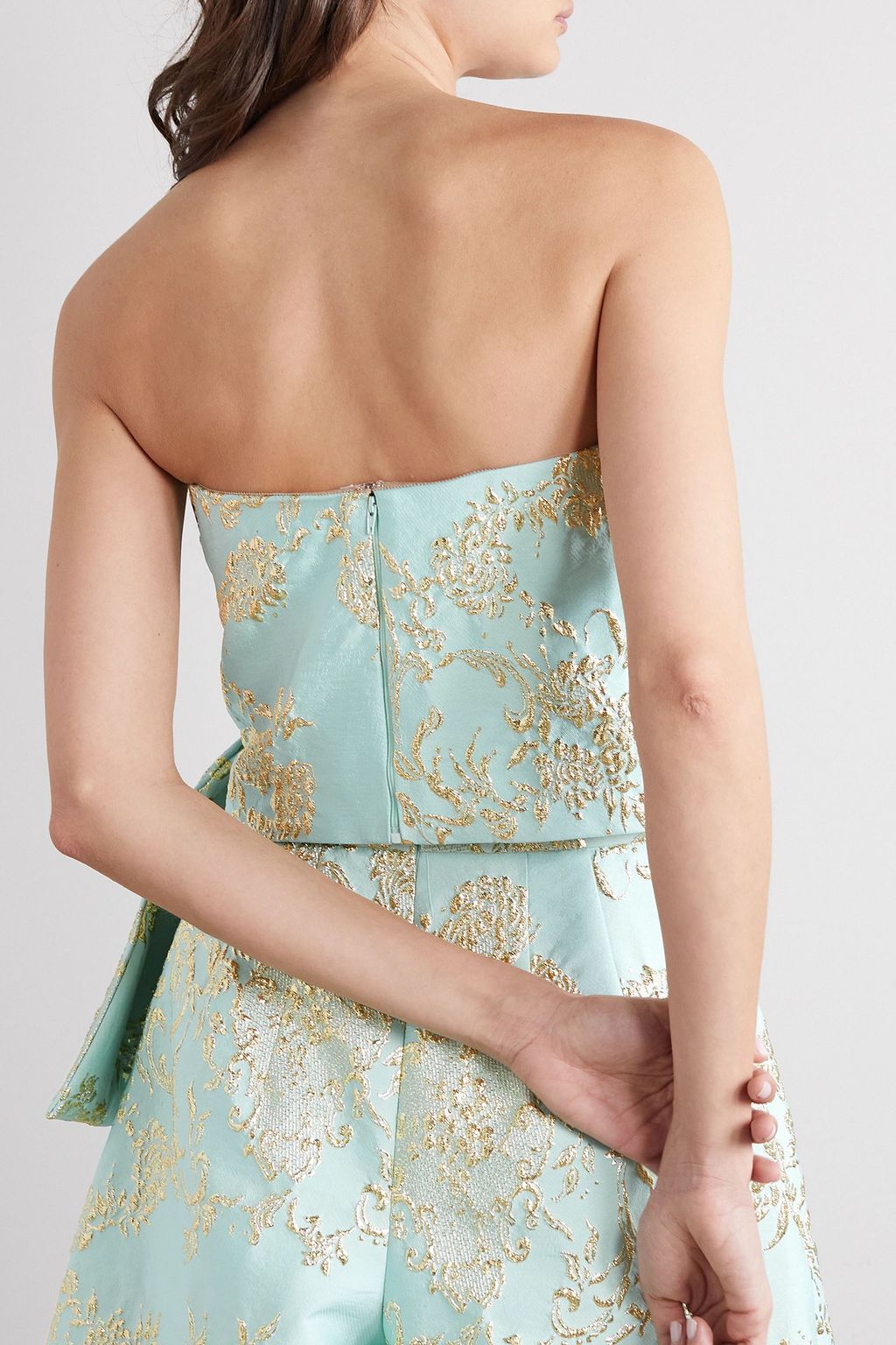 REEM ACRA بلوزة بقصة درابية بدون حمالات من البروكيد بلمعة معدنية مع عقدة