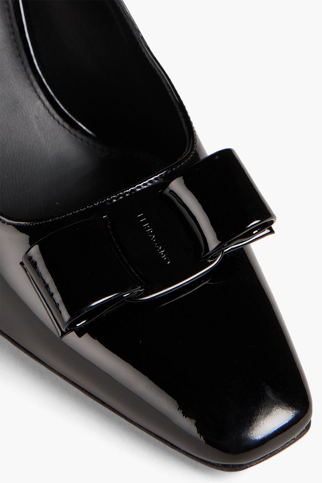 FERRAGAMO حذاء بامب مصنوع من الجلد اللامع ومزين بربطة على شكل فراشة